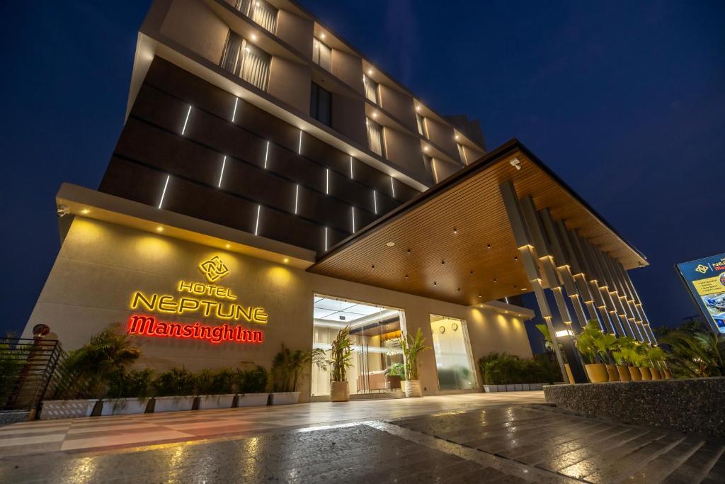 a hotel with a sign on the front of a building at Hotel Neptune Mansingh Inn in Morbi