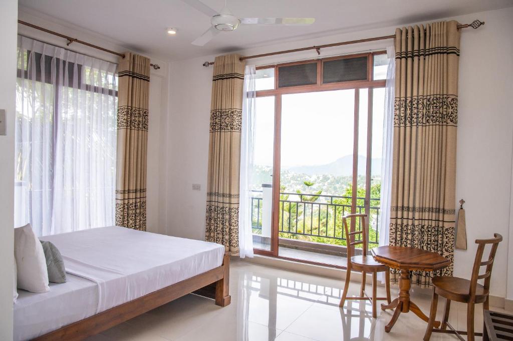 a bedroom with a bed and a large window at Windsor Crest in Kandy