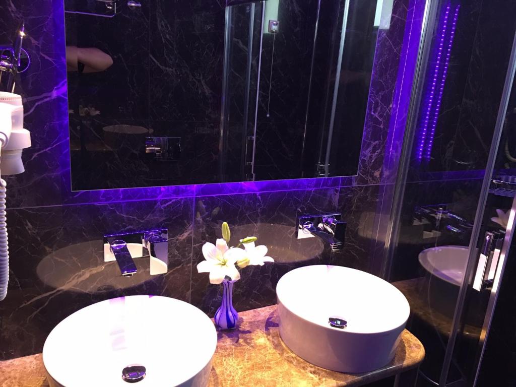 two sinks in a bathroom with purple lighting at Vergos Hotel in Vourvourou
