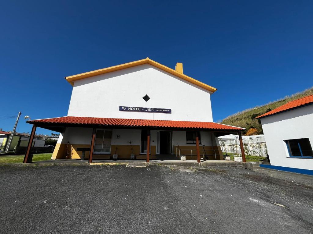 a white building with a sign on it at Hotel JSF in Horta