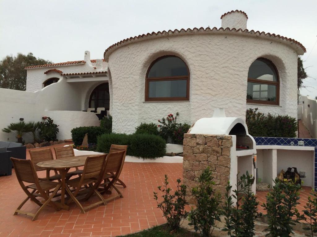 a patio with a table and chairs in front of a house at Villa Isola Rossa in Isola Rossa