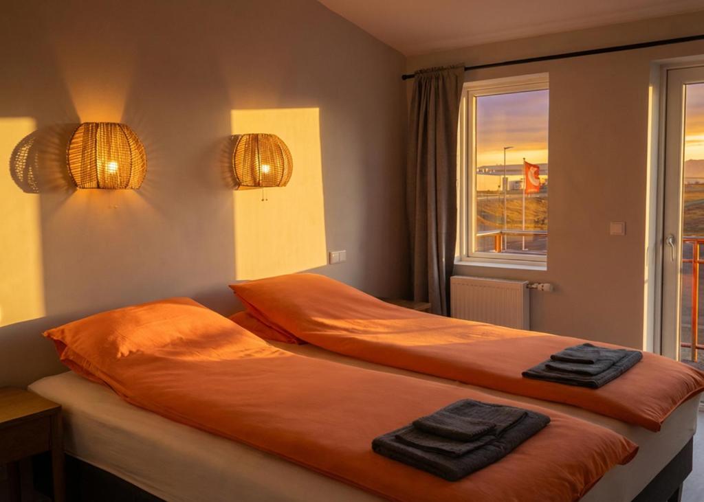 two beds in a room with towels on them at Faxaflatir Apartments in Hella