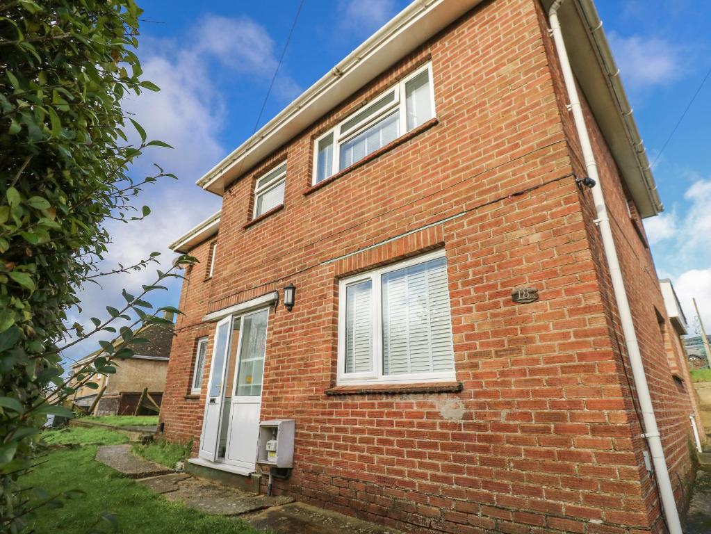 a red brick house with white windows on it at Red Brick Haven in East Cowes