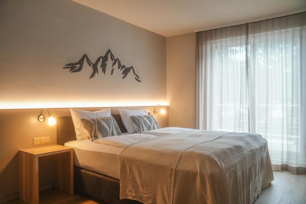 a bedroom with a bed with a mountain sign on the wall at Studio 54 Davos in Davos