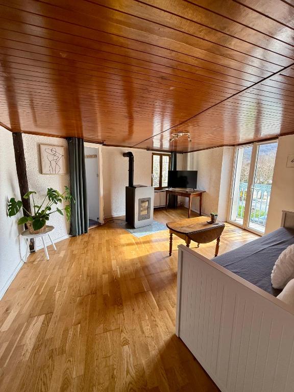 a living room with a bed and a wood stove at Face au chateau in Vizille