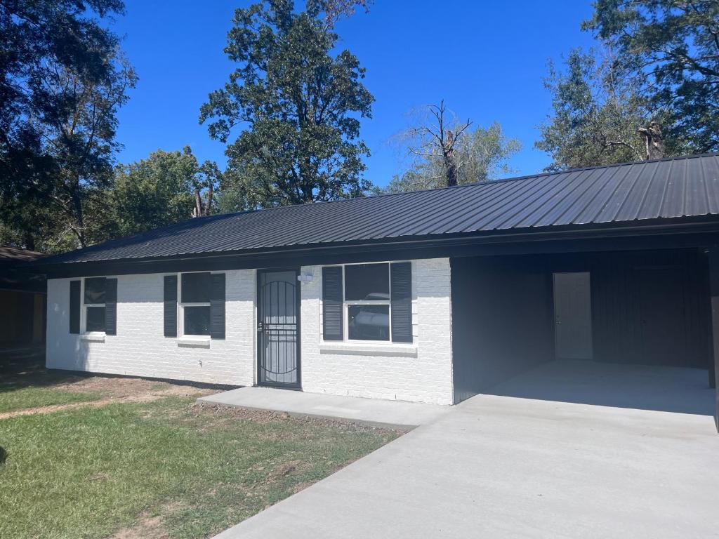 a small white house with a black roof at Heavenly Home in Monroe