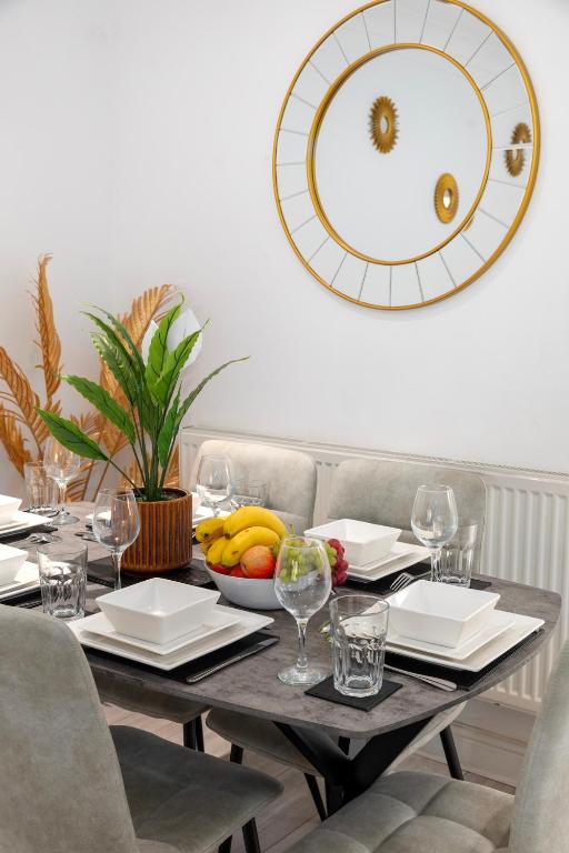 a table with a bowl of fruit and a large mirror at Contractor Accommodation, Free Large Car Park, Sleeps 7 in Kent