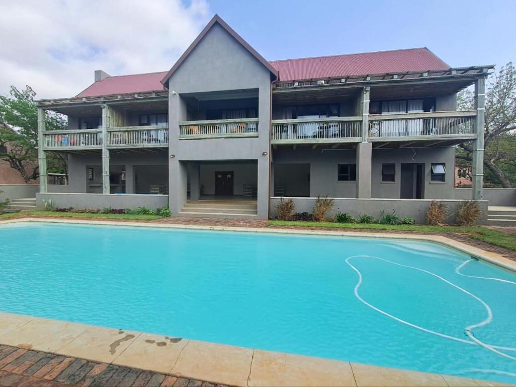 a house with a swimming pool in front of a building at The Lofts in Hoedspruit