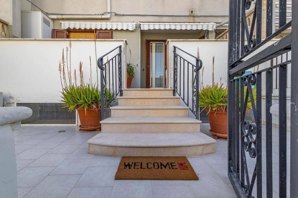 a welcome sign in front of a house with plants at Casetta Di Denny in Polignano a Mare