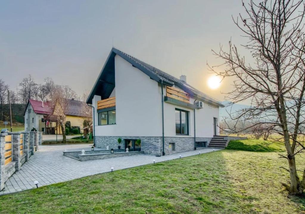 a white house with a black roof at JAMILO Home in Ściegny