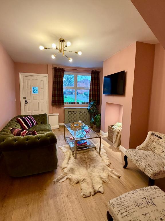 a living room with a couch and a glass table at Unique Vicarage Town Cottage in Leominster