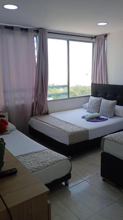 two beds in a room with a window at Cartagena Sotavento Laguito in Cartagena de Indias