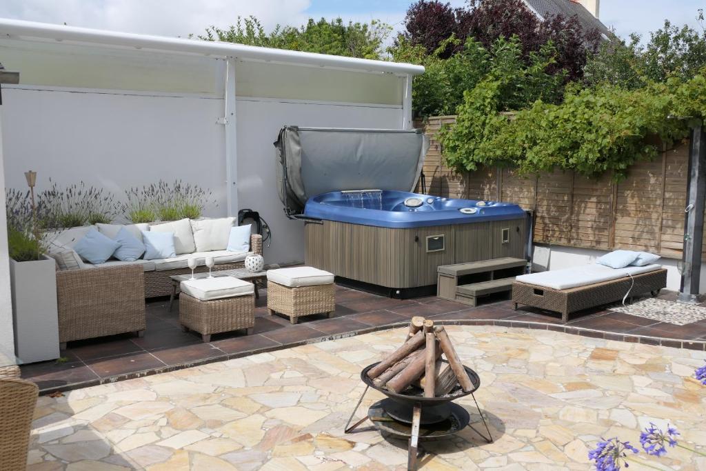 a patio with a hot tub and a couch at La Maison d'Adonis à la mer in Crozon