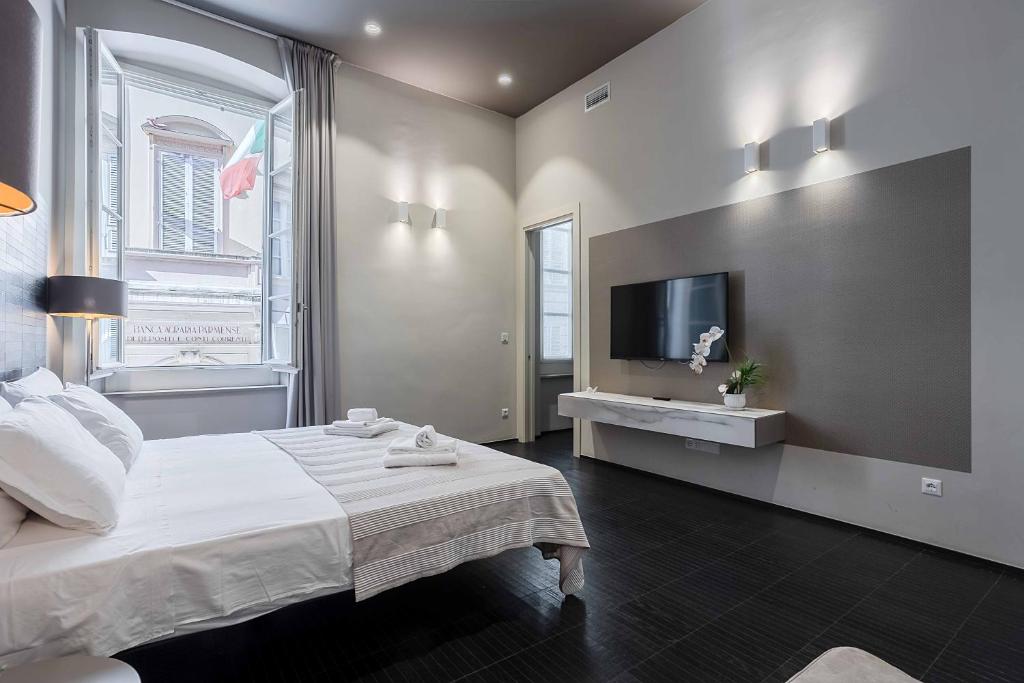 a bedroom with a bed and a tv on the wall at Salina Luxury Suites in Parma