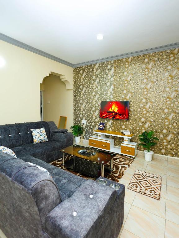a living room with a couch and a tv at Heavenly homes apartment in Mombasa