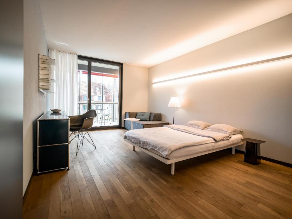 a bedroom with a bed and a desk and a chair at b20 - serviced apartments bern ag in Bern