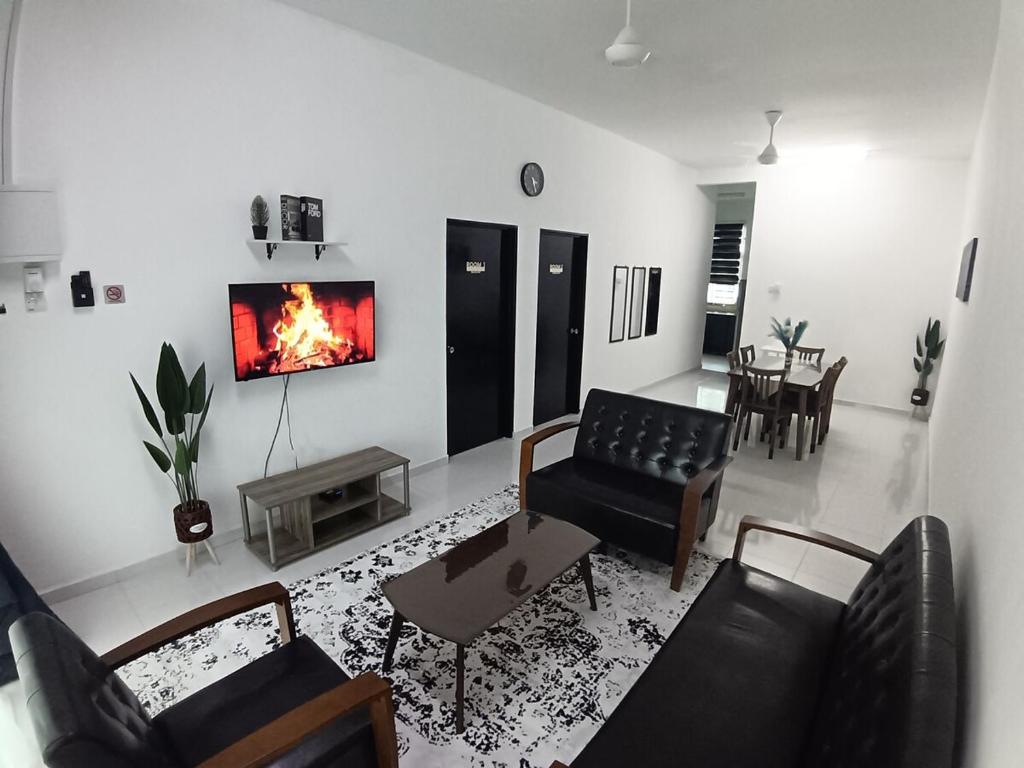 a living room with a couch and a fireplace at Babah Homestay in Merlimau