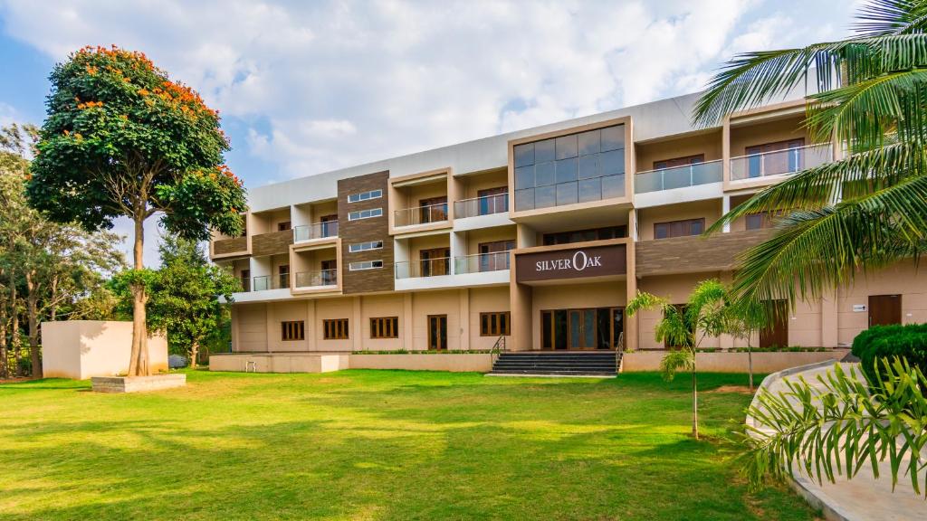 an apartment building with a lawn in front of it at Silver Oak Resort in Rājankunti