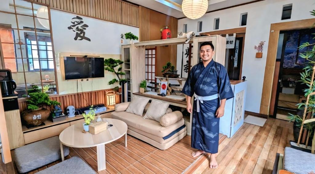a man is standing in a living room at Hanki Guest House syariah in Gadok 1
