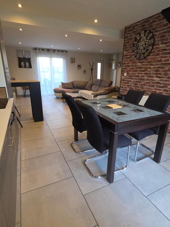 a kitchen and living room with a table and chairs at Casa chic in Saint-Dizier