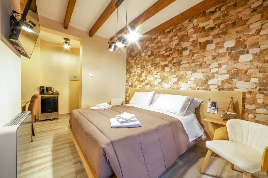 a bedroom with a large bed and a stone wall at Tzia Lillina B&B in Iglesias