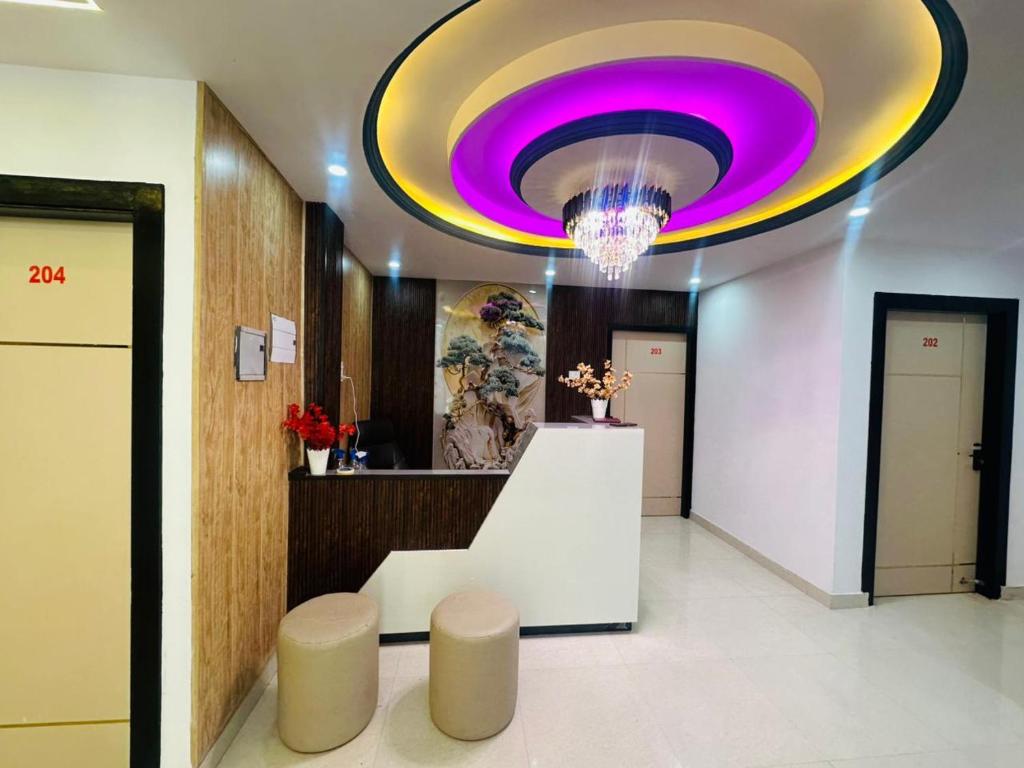 a lobby with a large ceiling with a purple light at Hotel Kunj Bihari in Lucknow