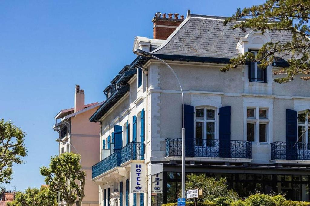 a white building with blue trim on a street at Hotel Edouard VII in Biarritz
