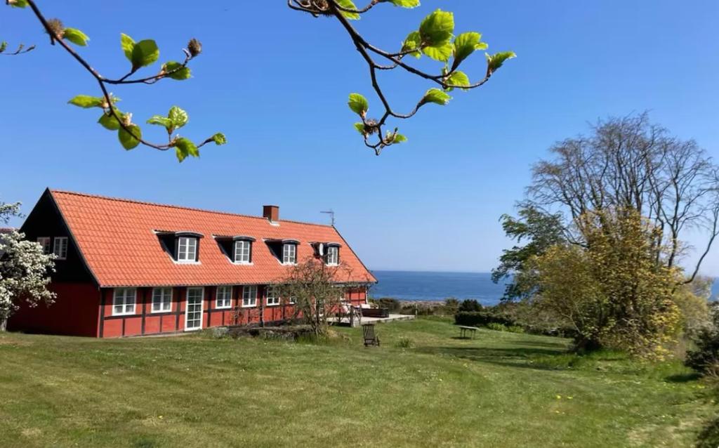 a red house on a hill with the ocean in the background at Wildernest Bornholm - Hjorten in Neksø