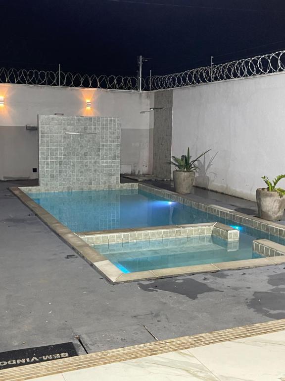 a swimming pool in the middle of a patio at night at Temporada Moto GP - 18km do autódromo de Goiania- acomoda 10 pessoas - Atlanta eventos in Goiânia