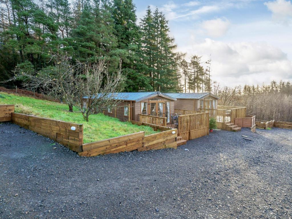 a home with a wooden fence and a cabin at The Orchard - Uk7111 in Alloa