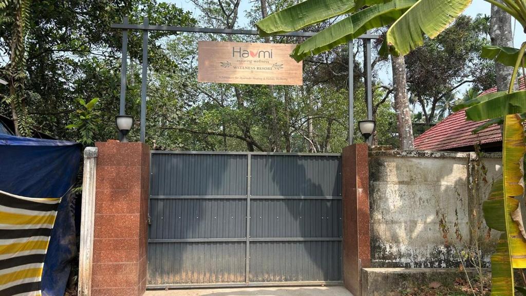 a metal gate with a sign on top of it at Havmi Wellness Resort in Kumarakom