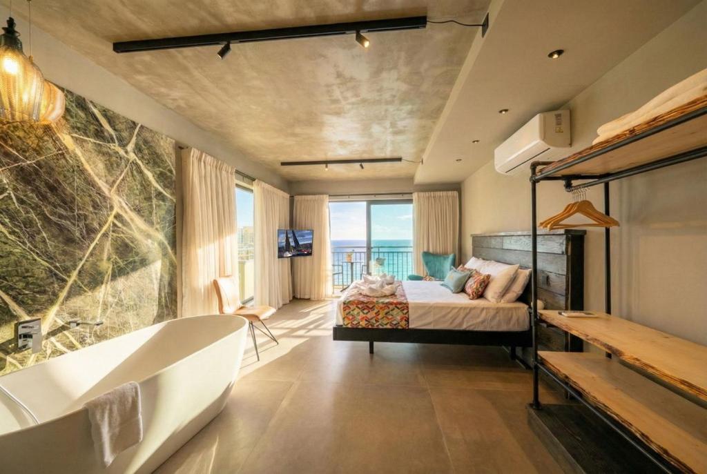a bedroom with a bath tub and a bed and a bath tub at Del Mar Court in Marsalforn