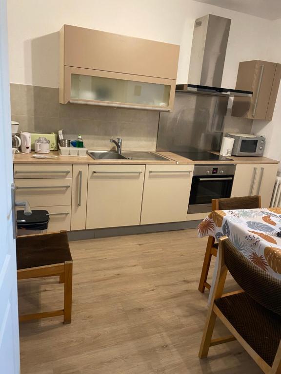 a kitchen with a sink and a stove top oven at Appartement Kylie in Néris-les-Bains