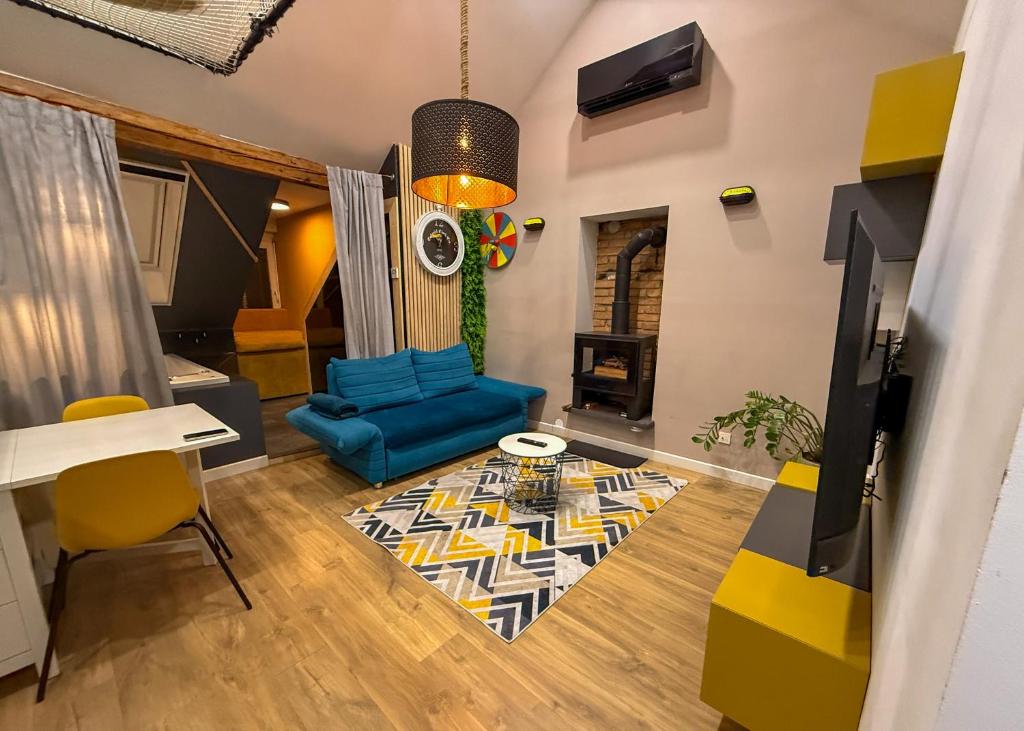 a living room with a blue couch and yellow chairs at Celia Center Celje Apartment in Celje