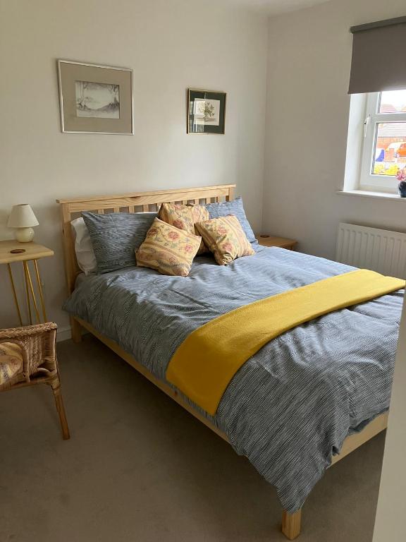 a bedroom with a bed with blue and yellow sheets at 18 Wixon Path in Buckinghamshire