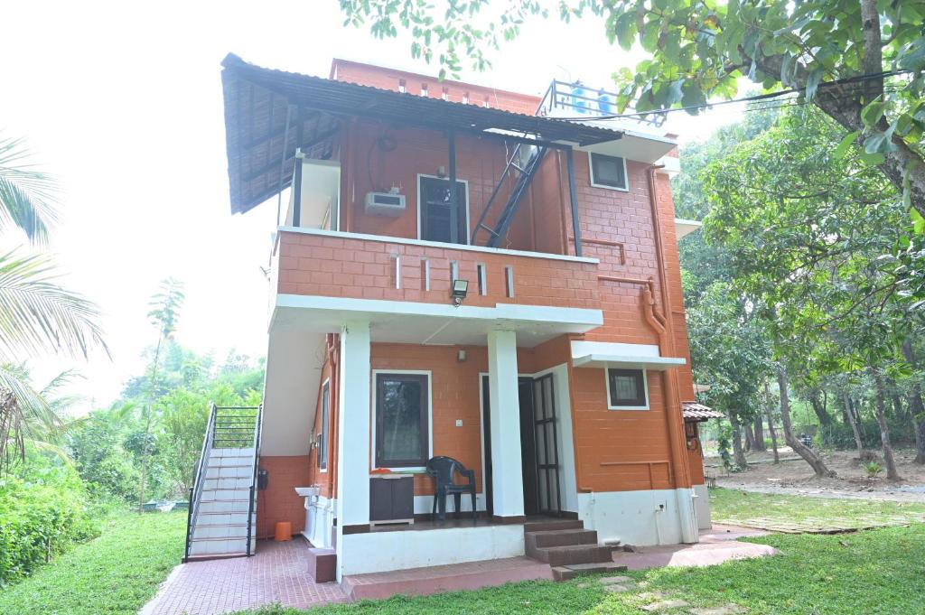 a house with a staircase in front of it at Nisarga Greens in Chittūr