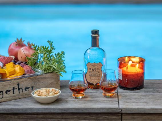 a bottle of wine and two glasses on a wooden table at Felina place by shuli in Ganne Yoẖanan