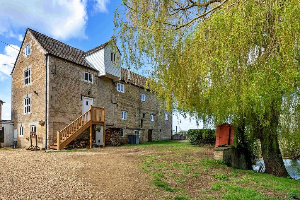a large brick building with a tree in front of it at Finest Retreats - Fletland Mill in Stamford