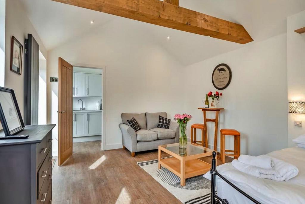 a living room with a couch and a table at Finest Retreats - The Den in Stamford