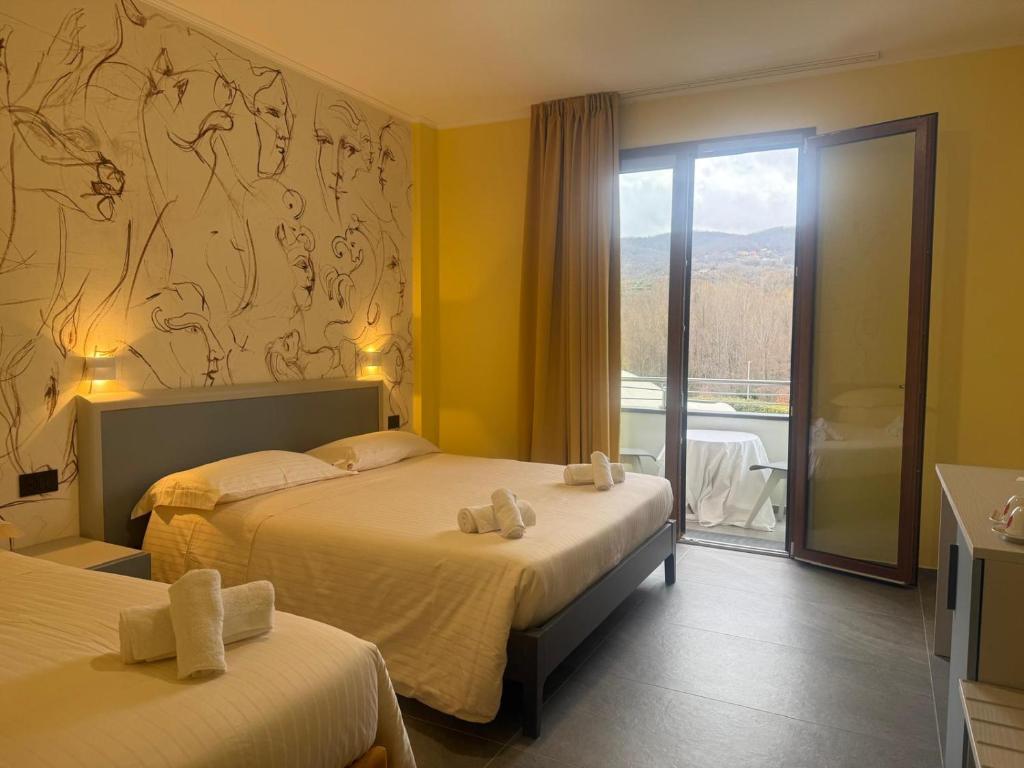 a hotel room with two beds and a balcony at Hotel Piccolo Paradiso - Latronico "Terme" in Latronico
