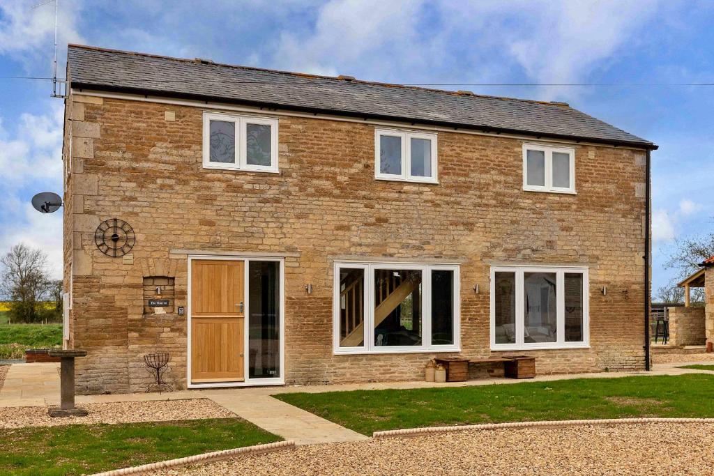 a brick house with white windows and a door at Finest Retreats - The Warren in Stamford