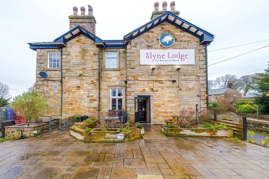 a stone building with a sign that reads singapore lodge at Slyne Lodge in Hest Bank