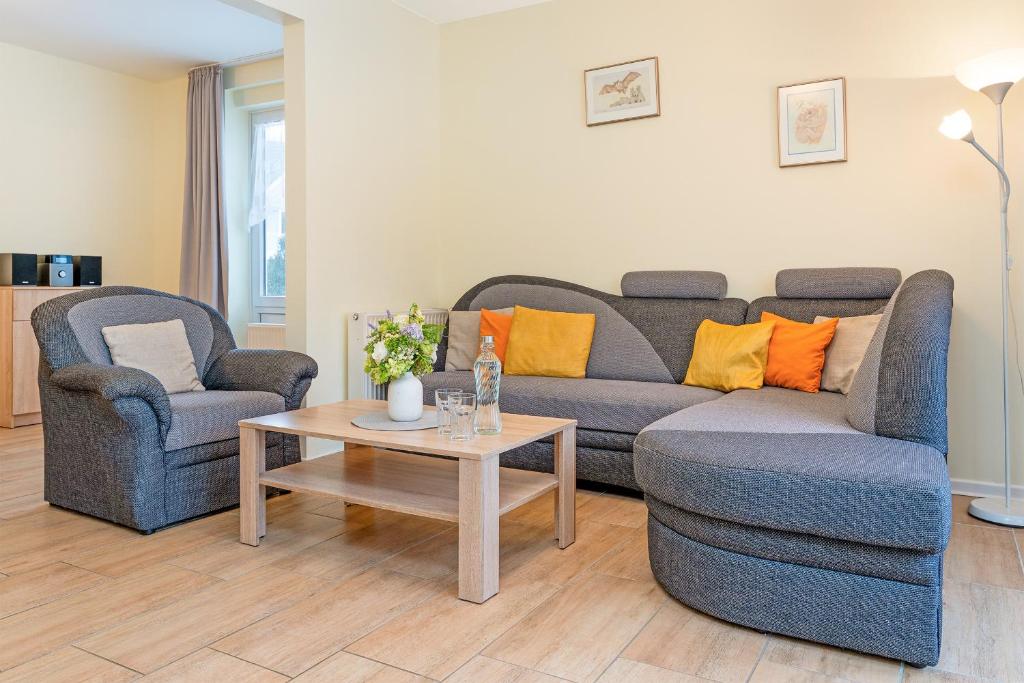 a living room with two chairs and a couch and a table at Haus 1 Matrose in Kellenhusen
