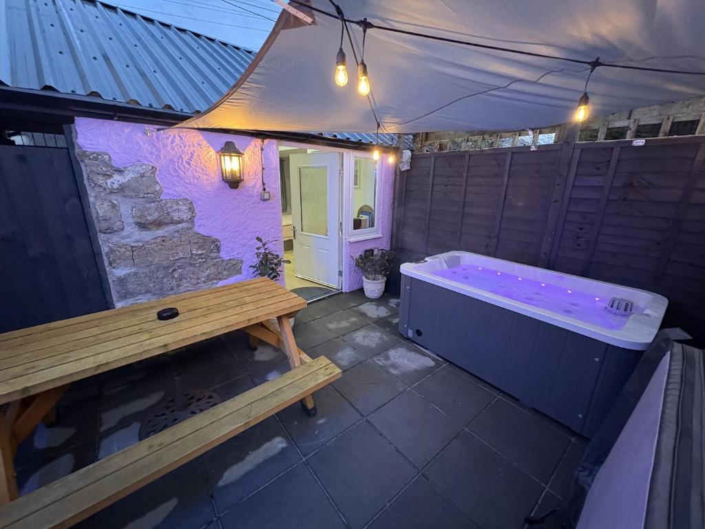 a bathroom with a tub and a bench in it at Robyns Retreat in Brynsiencyn
