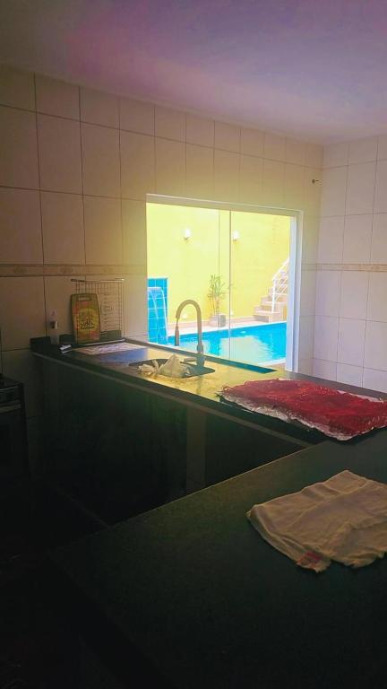 a kitchen counter with a sink and a window at Sonho de verão in Guarulhos