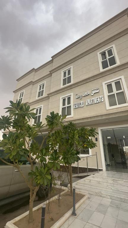 a building with trees in front of a store at Alhayat Star serviced apartments in Wadi Al Dawasir