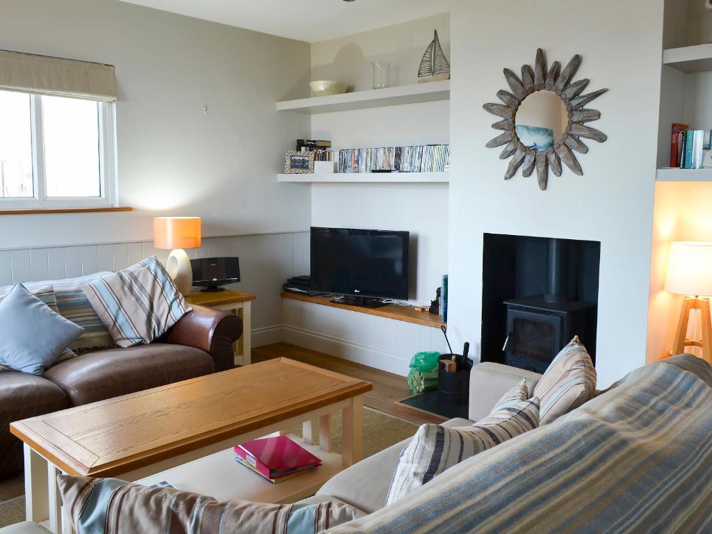 a living room with a couch and a fireplace at Gullsway in Beadnell