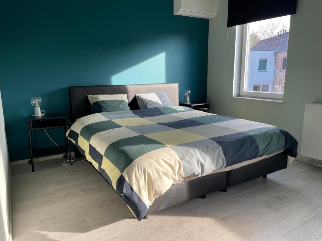 una camera da letto con un grande letto e una parete blu di JoHa Haus a Hasselt