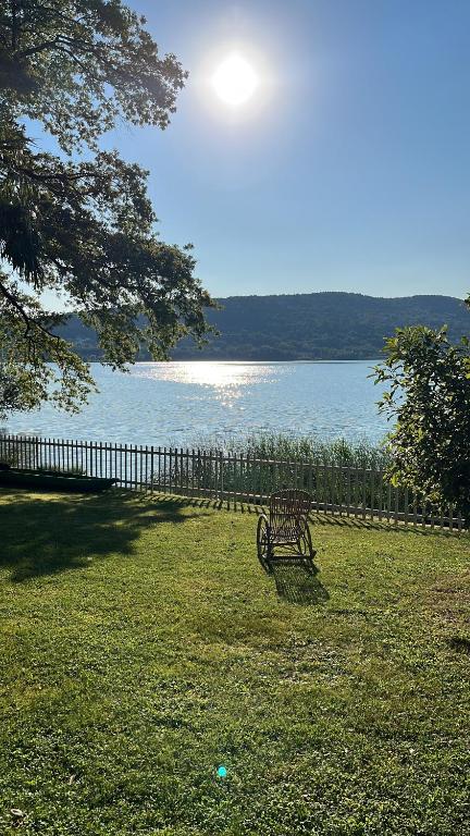 a park bench sitting in the grass near the water at Lake House in Vergiate