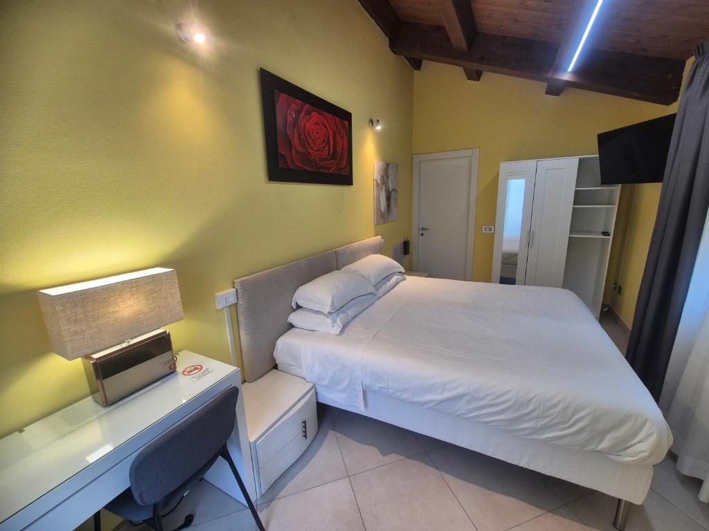 a bedroom with a bed and a desk with a laptop at B&B Bella di Notte in Lugo